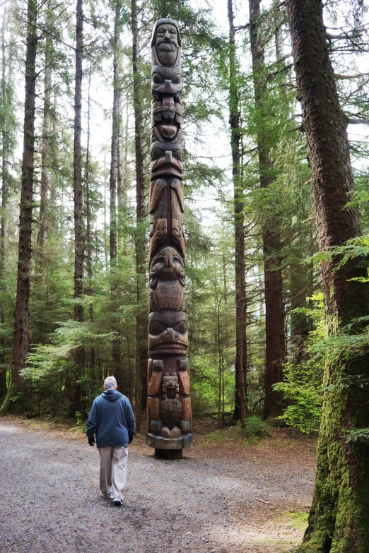 a totem on a dirt path surrounded by trees