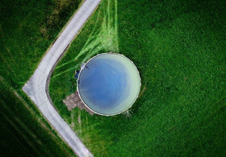 an aerial view of a grassy area with a round object in the middle of it