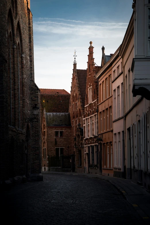 a large brown brick building towering over a cobblestone street