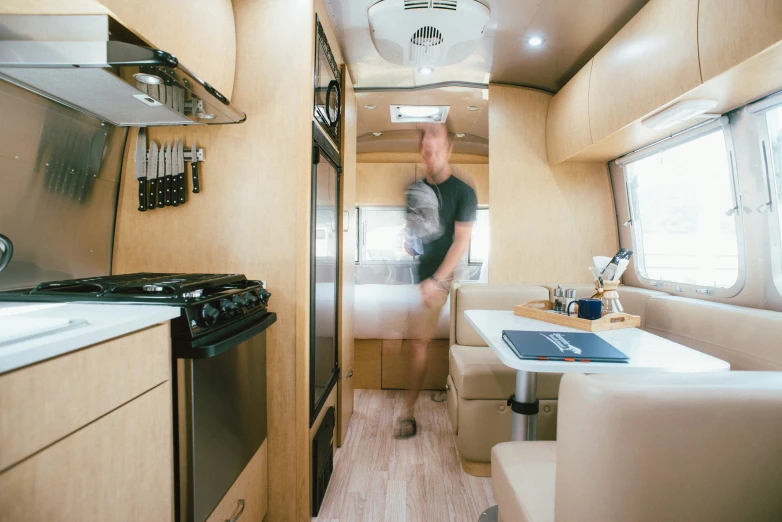 a man standing inside of a vehicle next to an oven