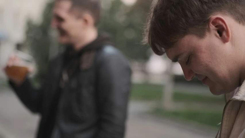 two guys with jacket and cell phone together