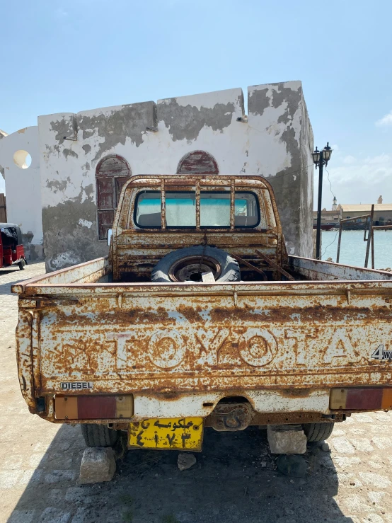 an old rusty truck parked in front of a building