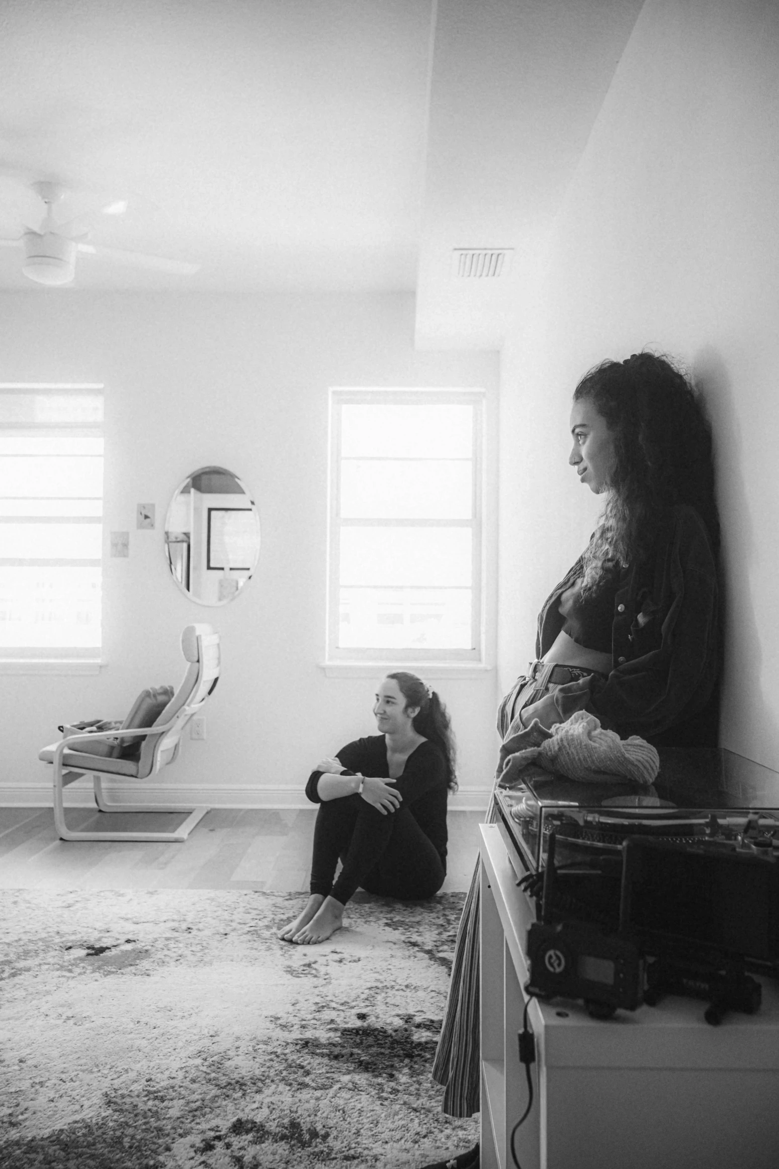 a young woman sits on the floor next to her friend