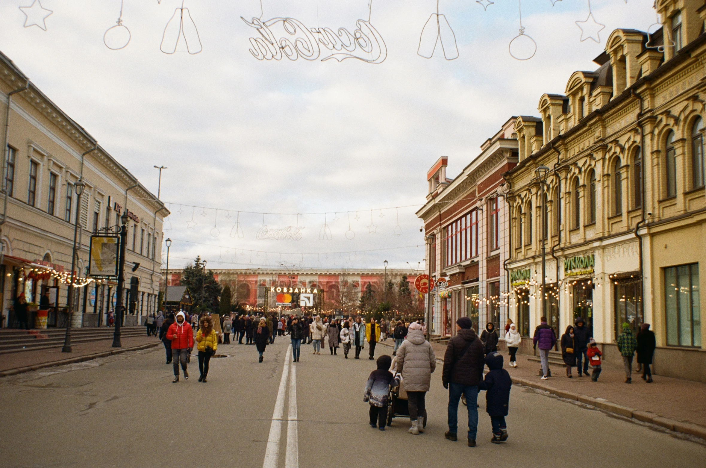 a large crowd walking down a street while holding onto people