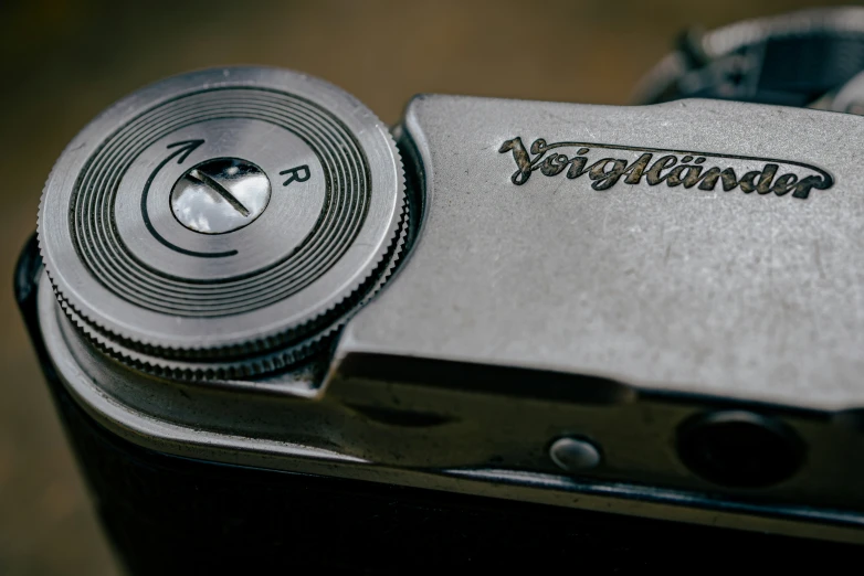 a close up of a silver camera with a logo