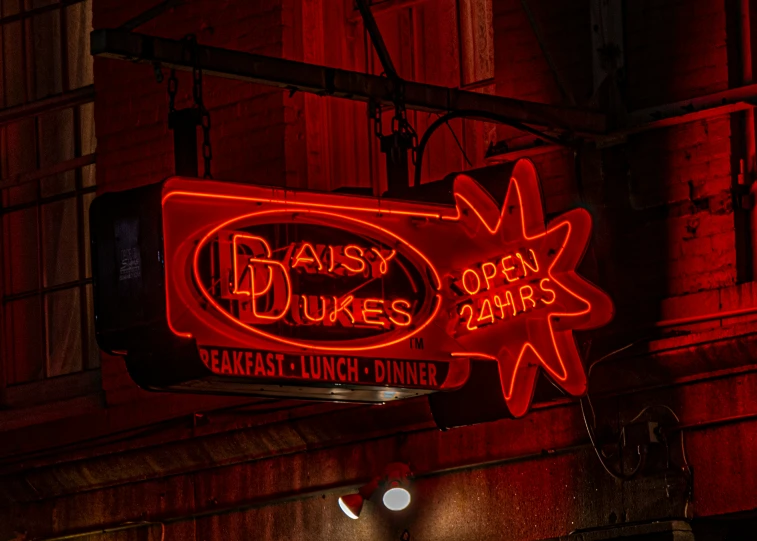 a big neon sign that is hanging from the side of a building