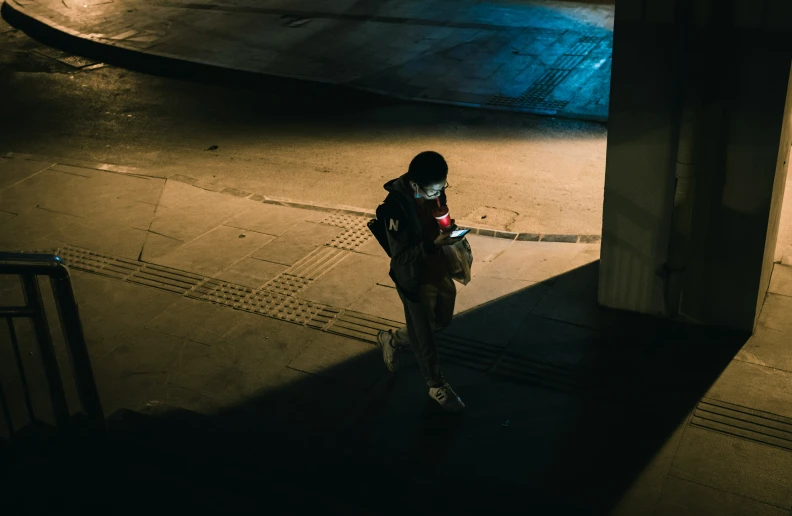 a person holding a bag while walking down a sidewalk