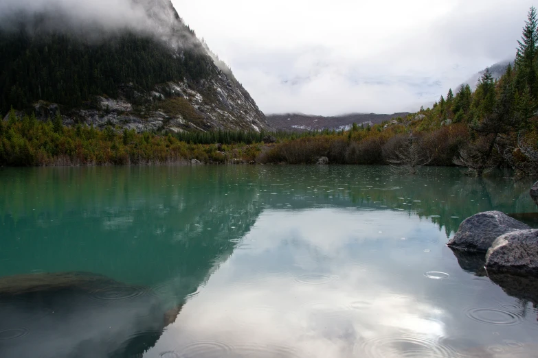 a lake with a mountain behind it in the middle of the woods