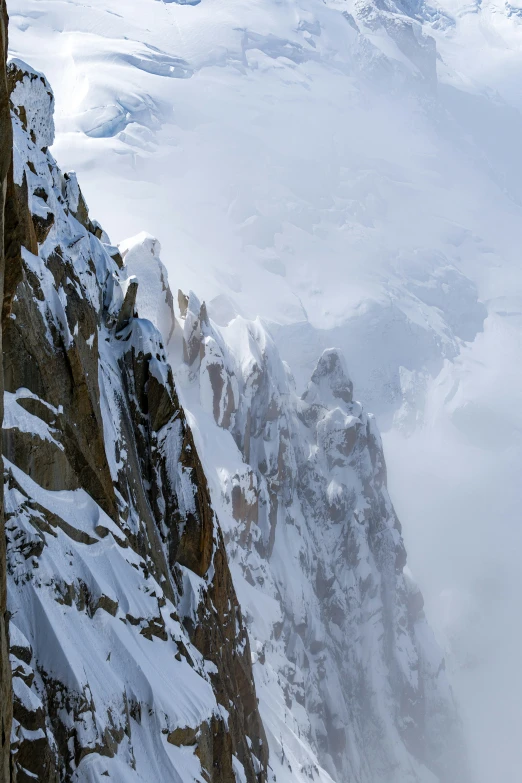 a snowy view looking down at a large mountain range