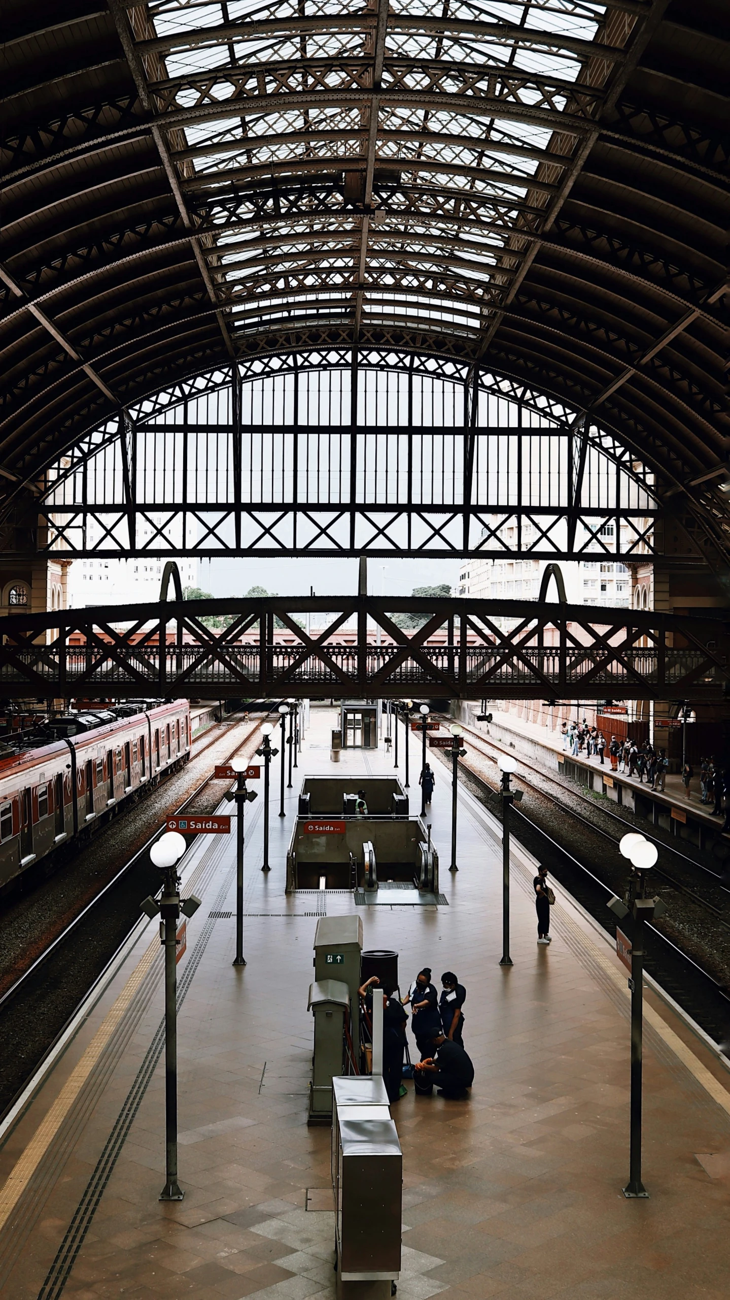 people are sitting at the train station as they wait for their trains