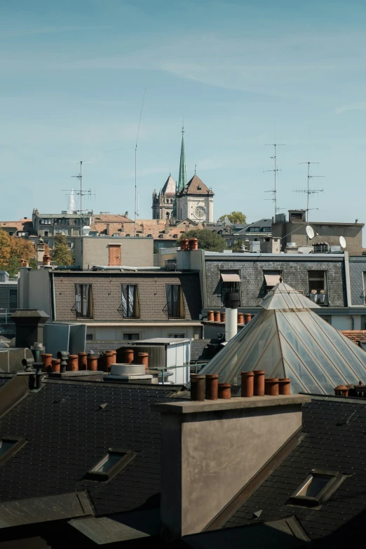 a large group of roofs with a clock tower in the background