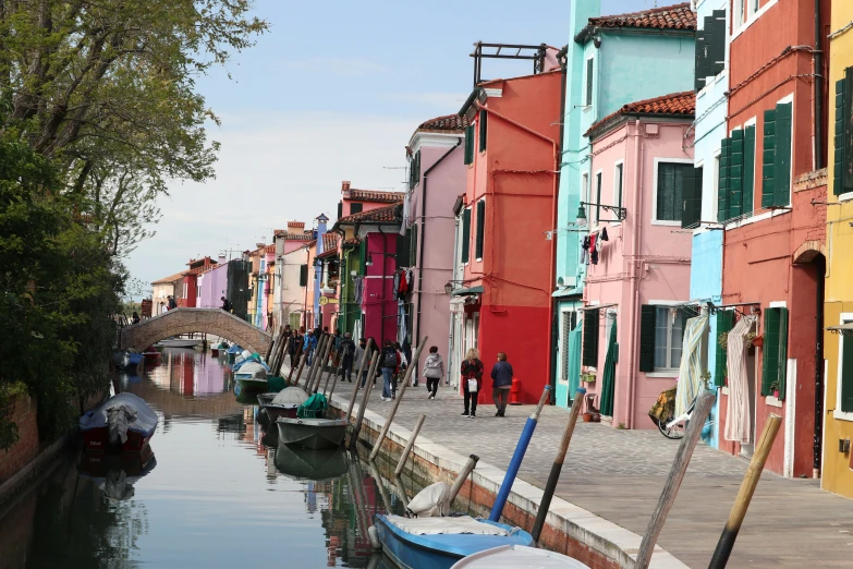 many different colored buildings along the water with boats in it