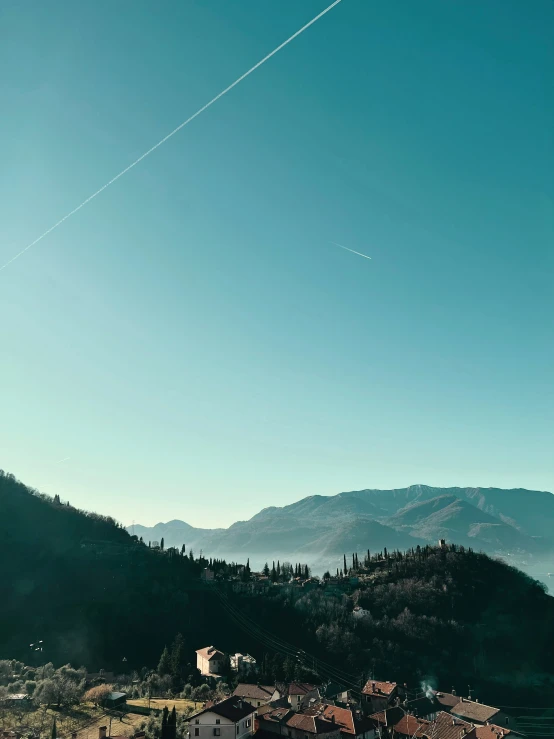 some buildings and hills with airplanes flying in the sky