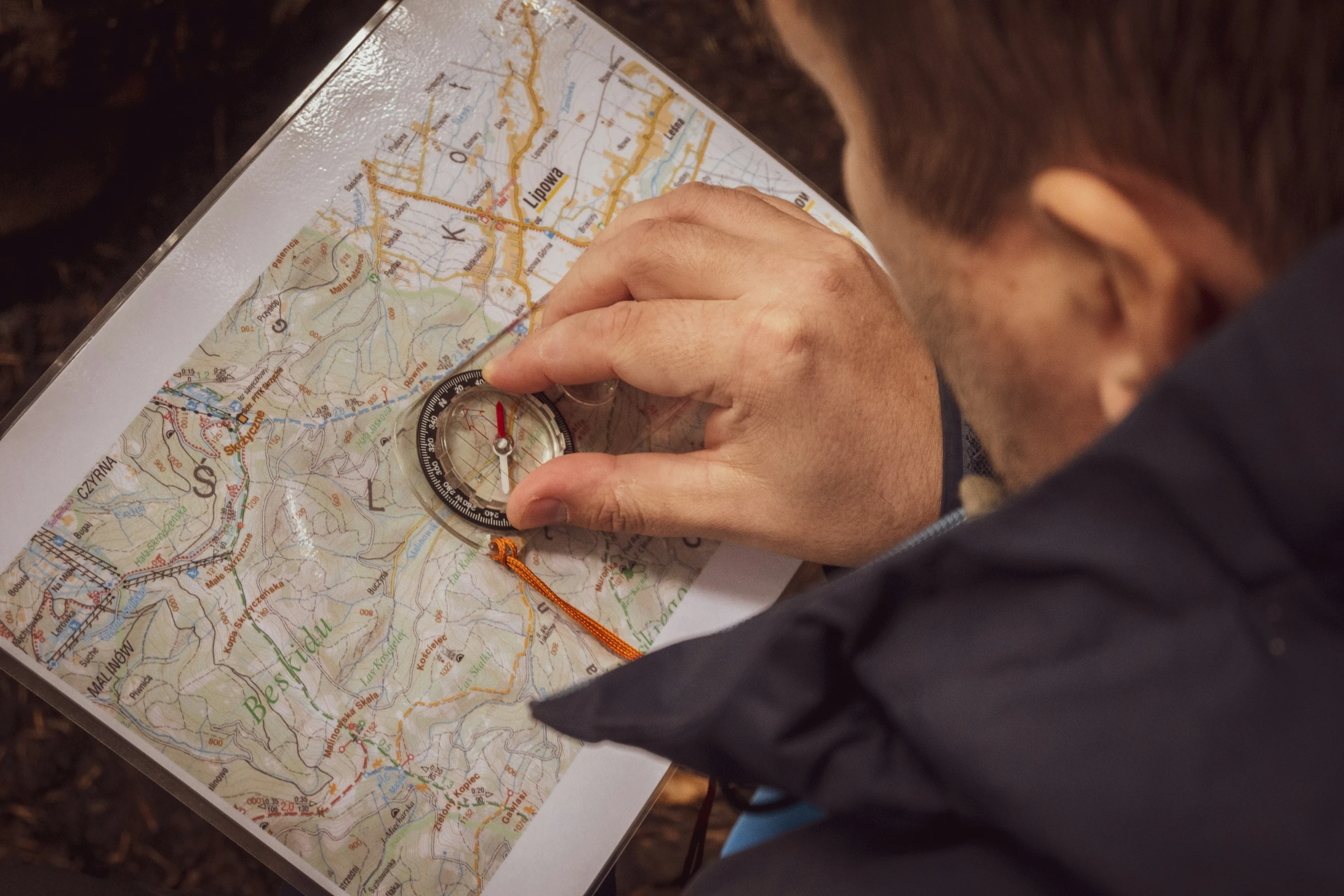 a man using a compass to find directions in the map