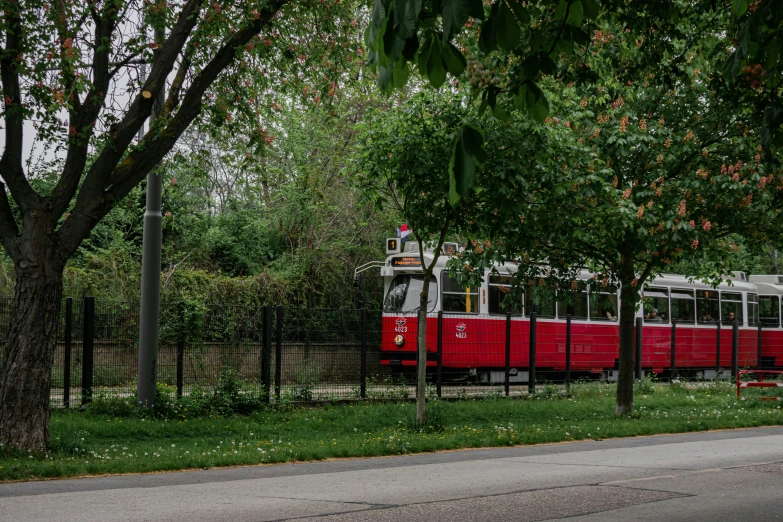 an old style train is moving through a park