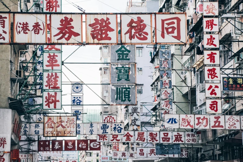 chinese sign are hanging on wires above a street