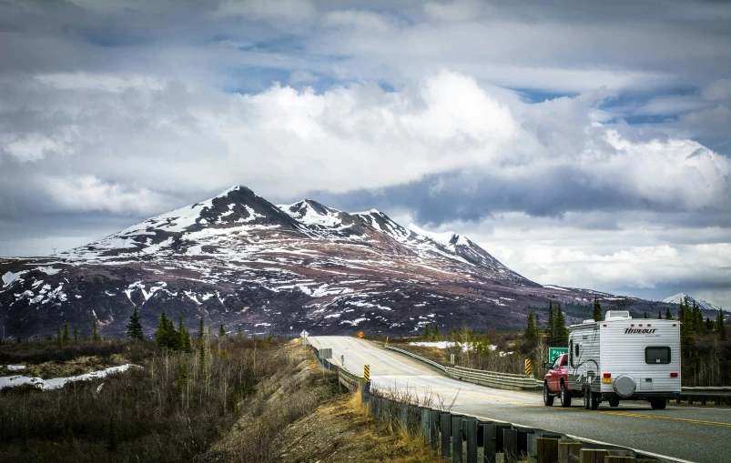 a large mountain that is sitting above the road