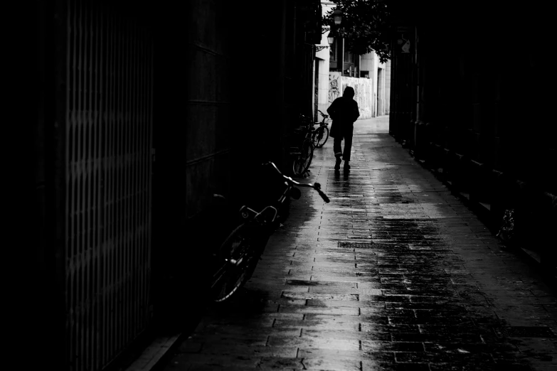 the silhouette of a person walking down a dark alley