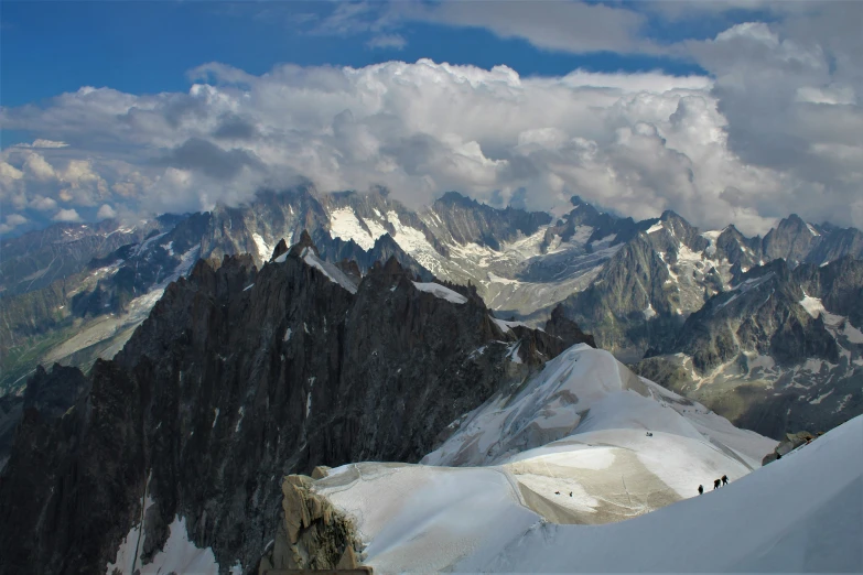 snow capped mountains with clouds above them