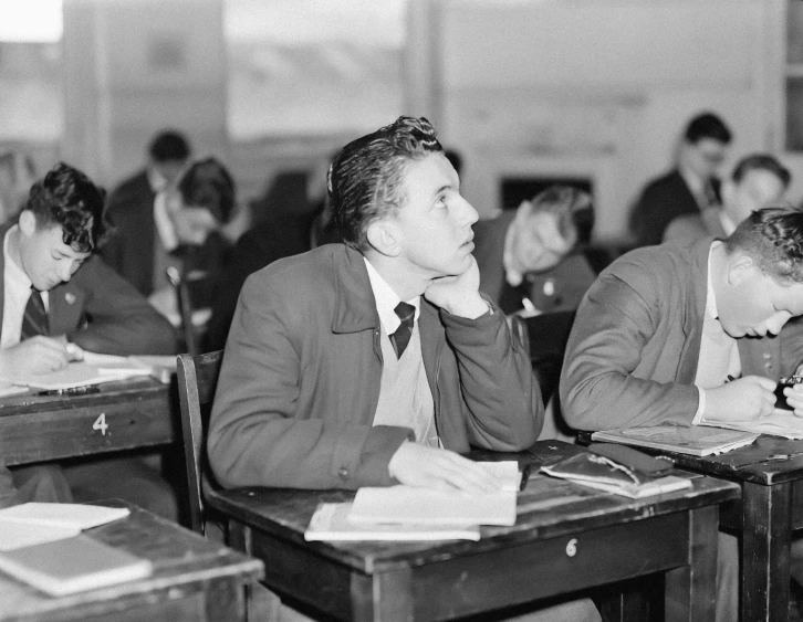 an old picture of people in a classroom with desks