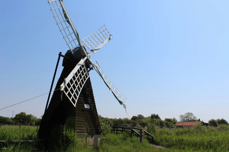 a windmill sitting on top of a lush green hillside