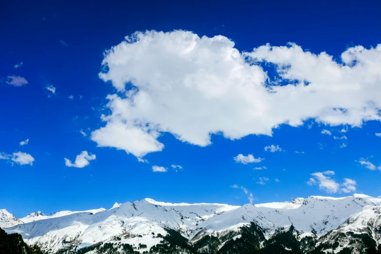 the view of a mountain range with snow in the foreground