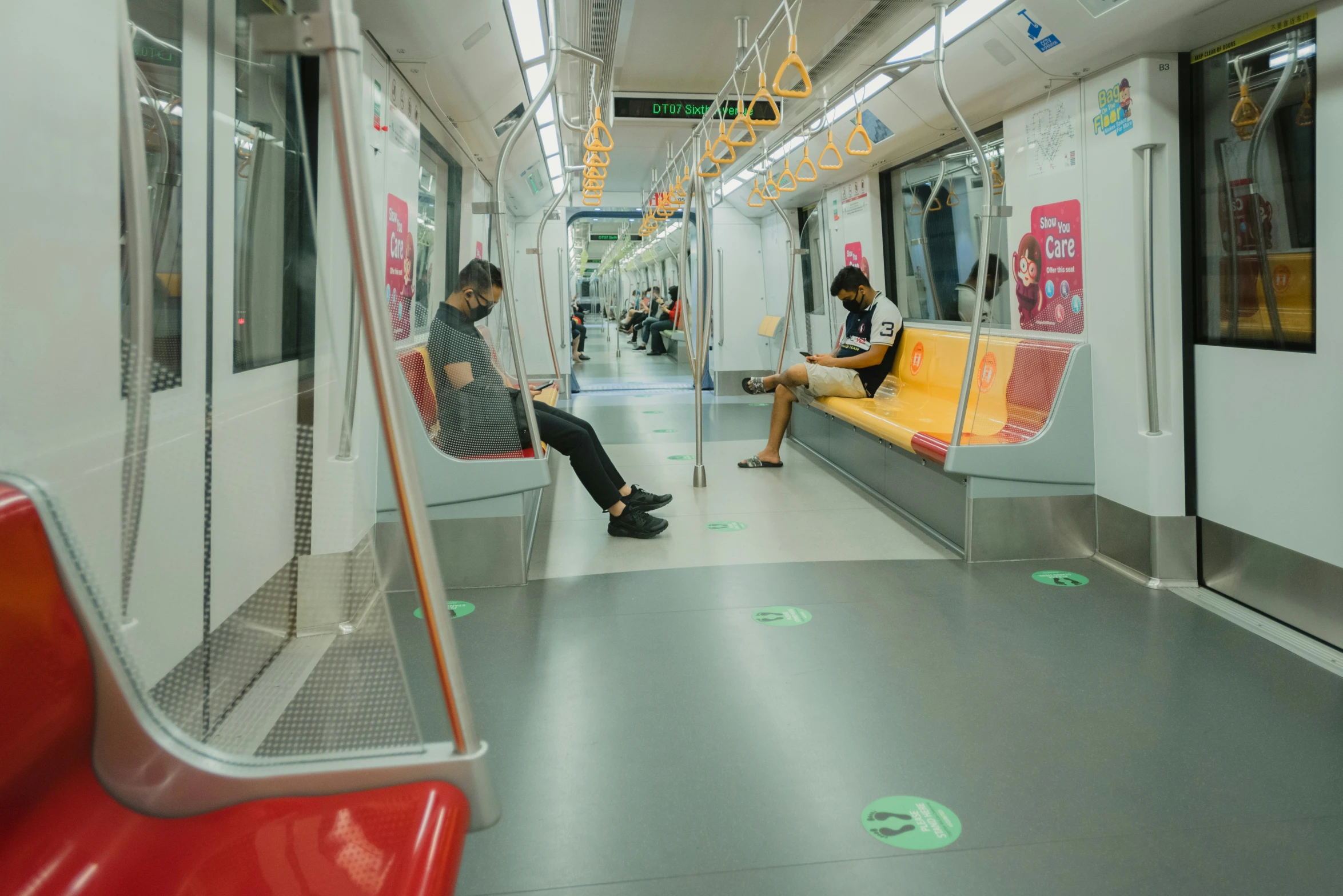 two people are sitting in a subway car