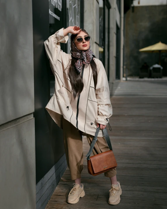 woman leaning up against building holding purse