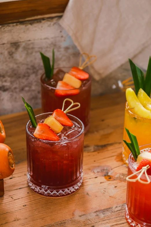 several alcoholic cocktails with garnish, fruit and pineapple