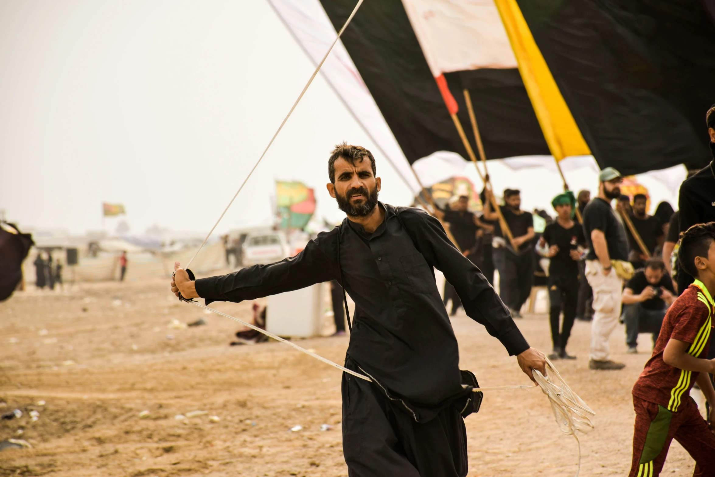 an older man is holding a kite at the beach