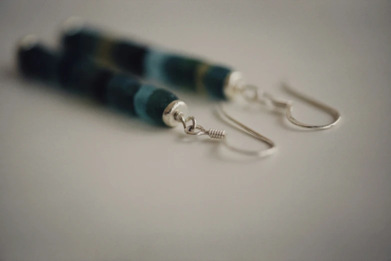 these earrings are made of two very long beads and metal hooks