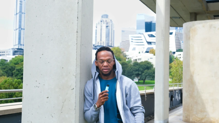 a man in a grey jacket is looking at his cell phone