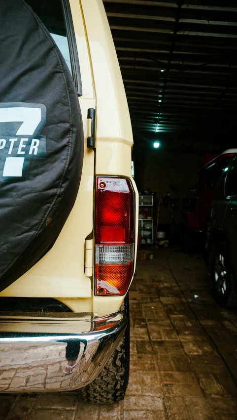 the rear end of a yellow pickup truck in a warehouse