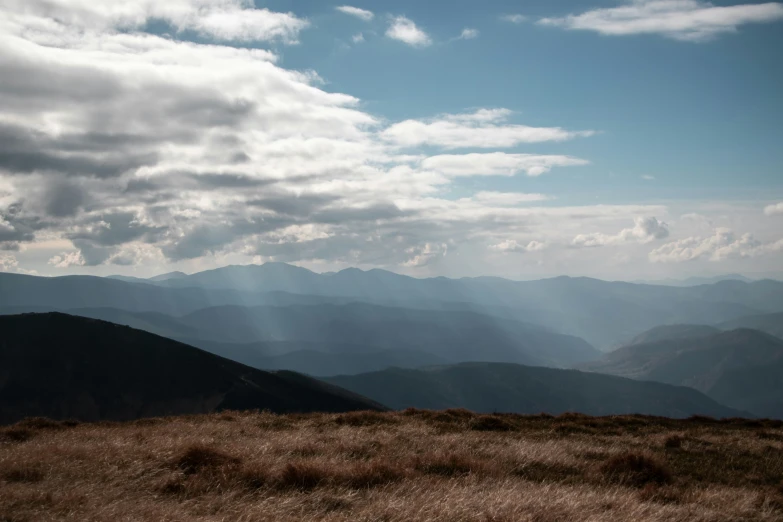 a large mountain range with some white clouds in the background