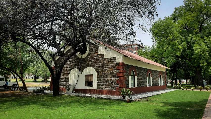 the old brick building in the park is red and white