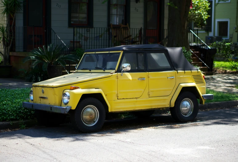 a yellow mercedes benz parked outside of a home