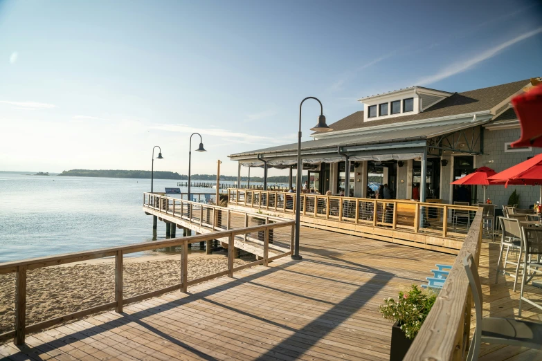 a deck at the end of a pier with umbrellas over it