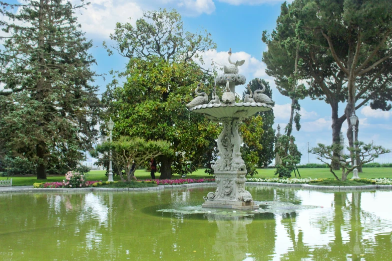 a fountain has animals and birds on it