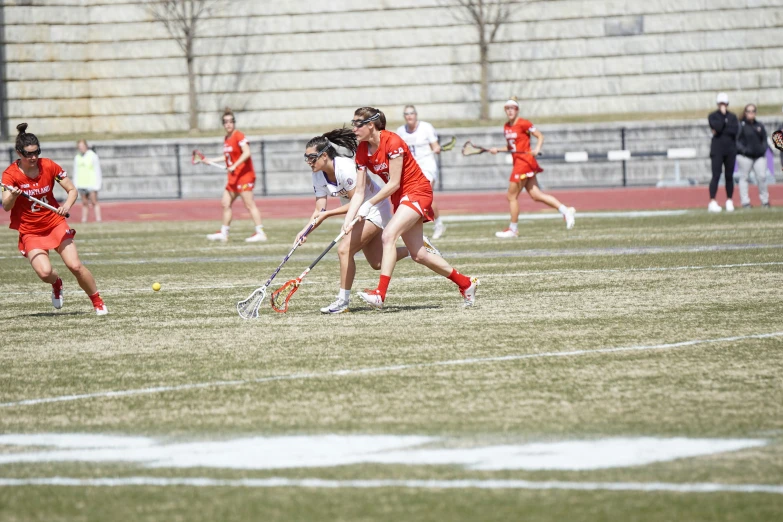 a group of women playing a game of lacrosse