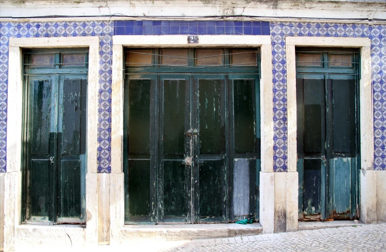 two doors in the same color on a wall with tile