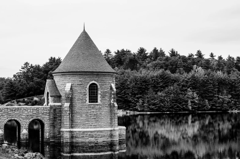 an old tower on the side of a lake
