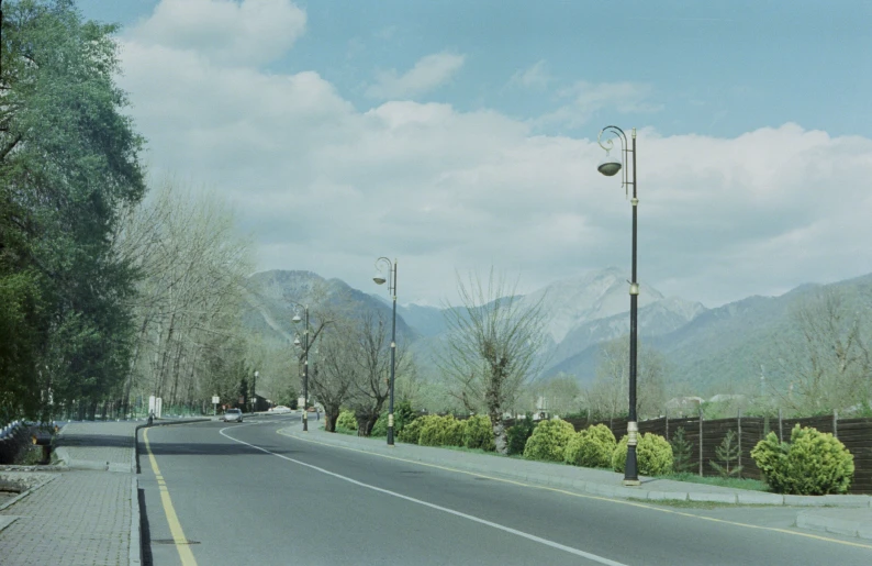 an empty street has a mountain backdrop