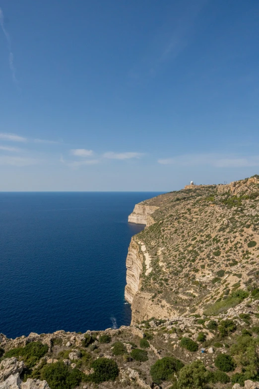 a horse standing on top of a rock cliff