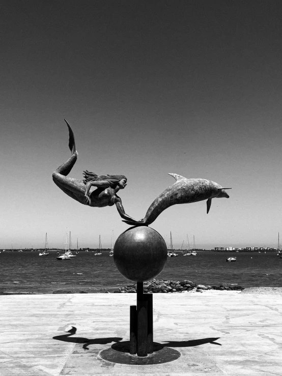 statue of an angel and dolphin on the beach