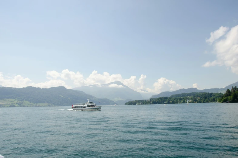 boat floating on calm, still water with mountain background