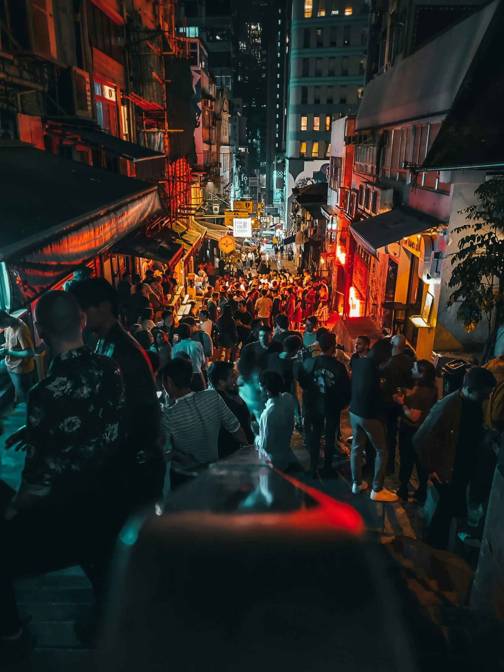 a crowded street full of people walking at night