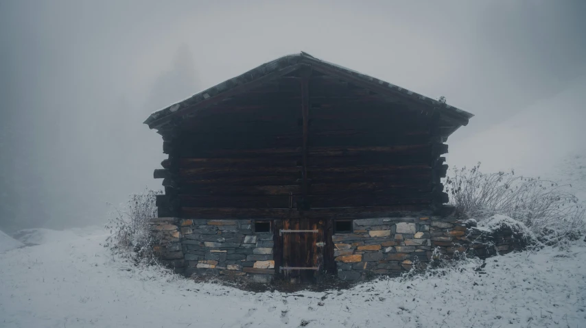 an old log cabin in the snow