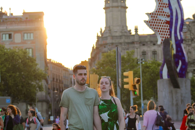 a man and woman smile while walking on the street