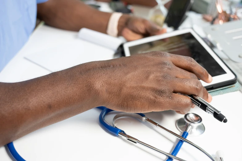 a male doctor is using a tablet while laying down