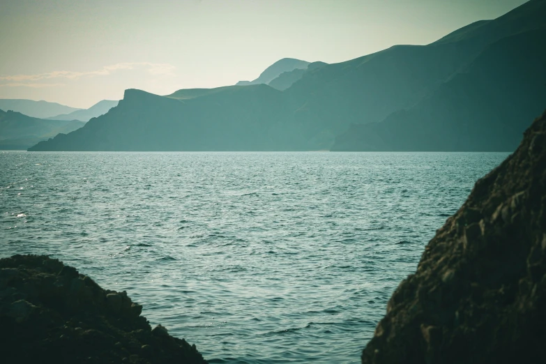 view from a rocky outcropping onto the ocean with mountains